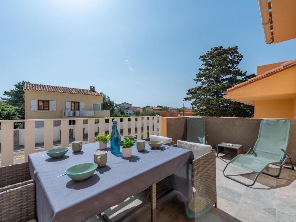 une table sur un balcon avec des bols et des vases dessus dans l'établissement Apartment Pine's Mansion-1 by Interhome, au Barcarès