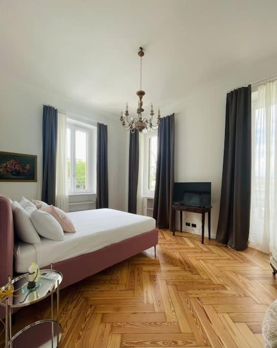 a bedroom with a bed and a table and windows at L'Adagio in Gran Madre in Turin