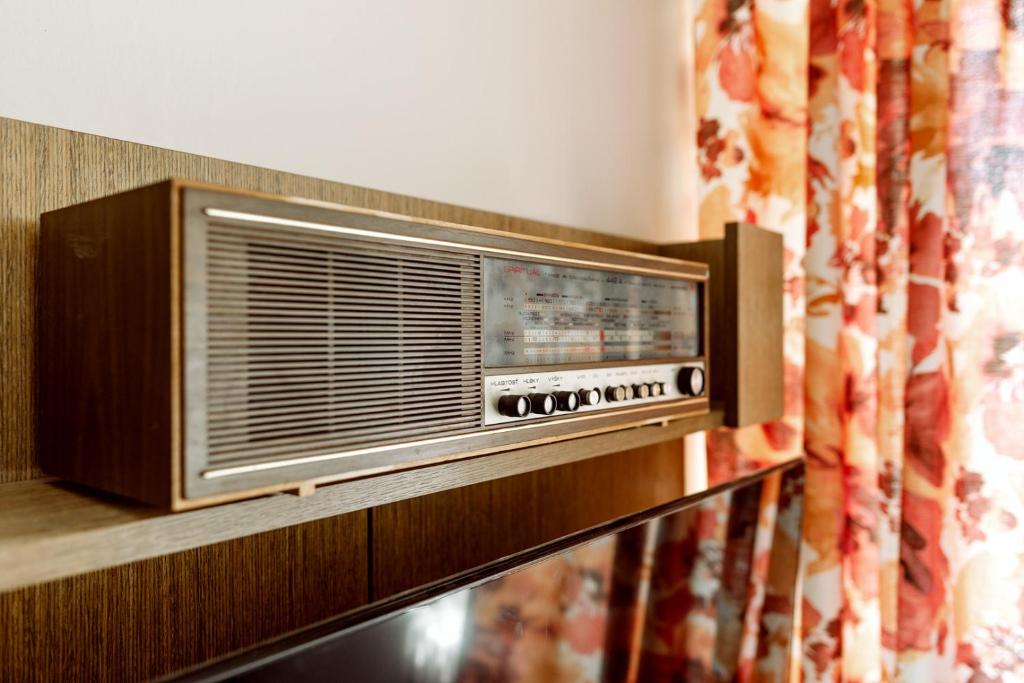 an old radio sitting on a shelf next to a curtain at Retro Hotel JISKRA in Čeladná