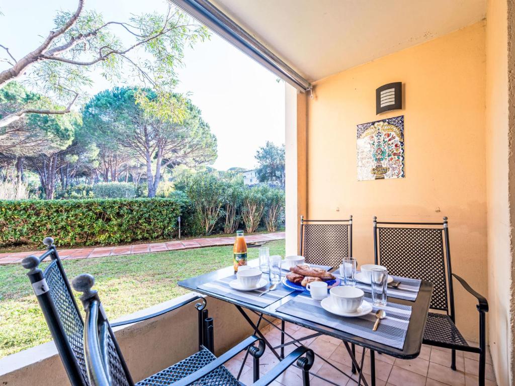 une table et des chaises sur une terrasse avec une grande fenêtre dans l'établissement Apartment Caesar Domus-5 by Interhome, à Saint-Tropez