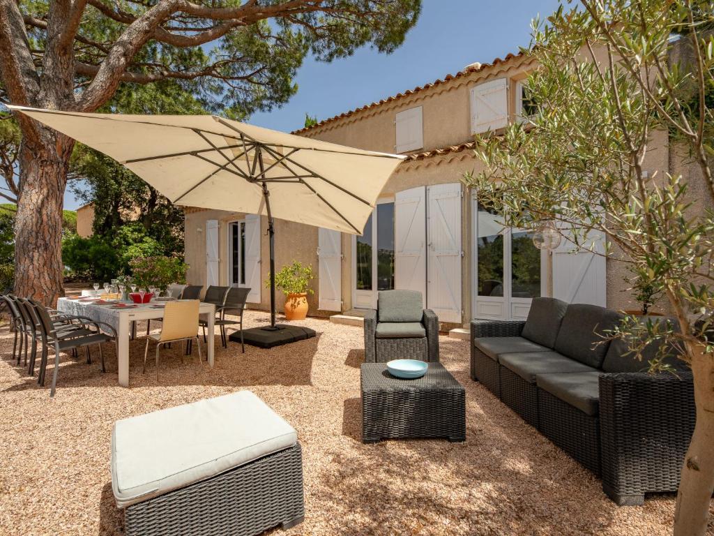 une terrasse avec un canapé et un parasol dans l'établissement Holiday Home Riviera by Interhome, à Sainte-Maxime
