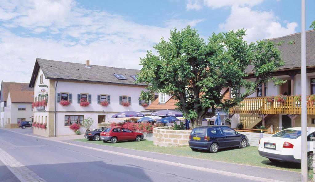 uma rua com carros estacionados em frente a um edifício em Gasthof Krapp em Litzendorf