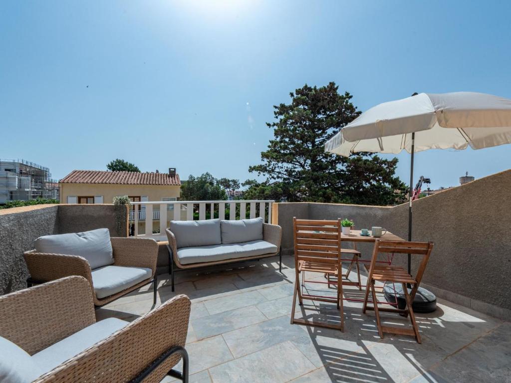 un patio avec des chaises et une table avec un parasol dans l'établissement Apartment Pine's Mansion-2 by Interhome, au Barcarès