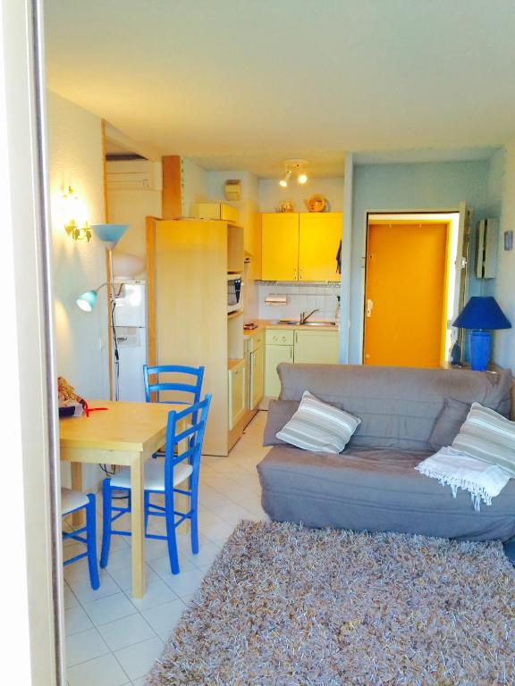 Appartment Plein Soleil في جولف جيون: غرفة معيشة مع أريكة وطاولة