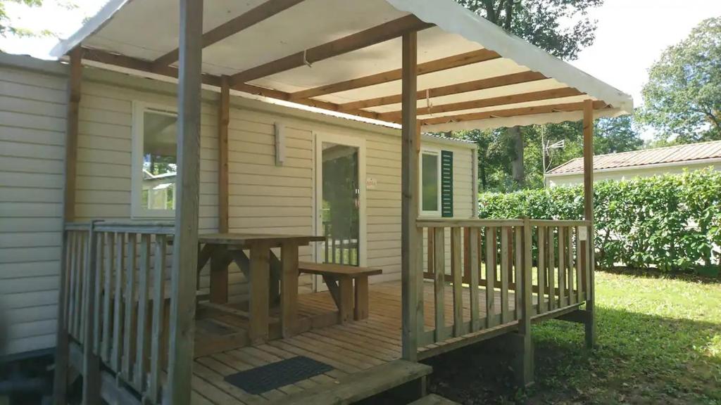 une pergola en bois avec une table de pique-nique sur une terrasse dans l'établissement 45mn de Paris - Beau mobilhome pour famille et travail, à Saint-Chéron