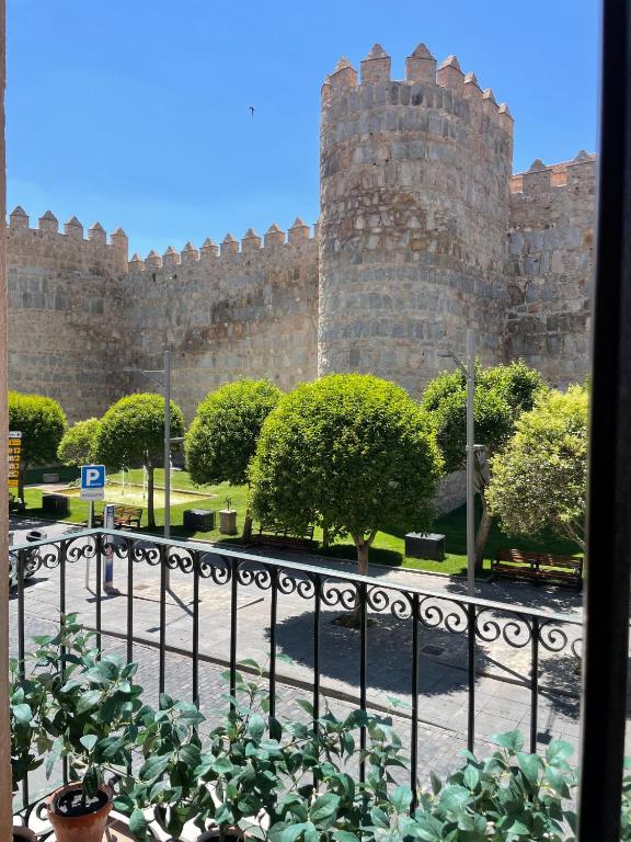 a castle with a fence in front of it at El balcón de la Muralla in Ávila