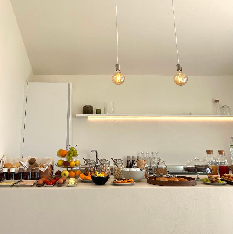 a kitchen counter with plates of food on it at Vireo Rooms in Santa Maria Navarrese