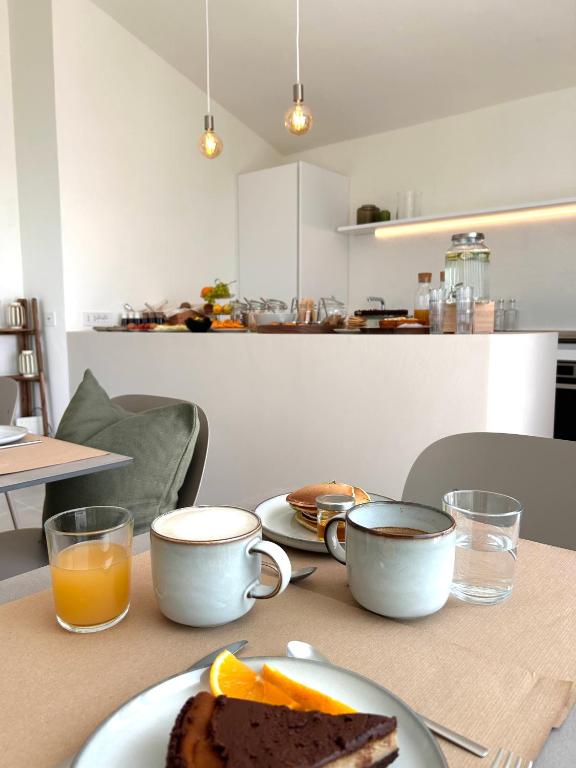a table with a plate of bread and two cups of coffee at Vireo Rooms in Santa Maria Navarrese