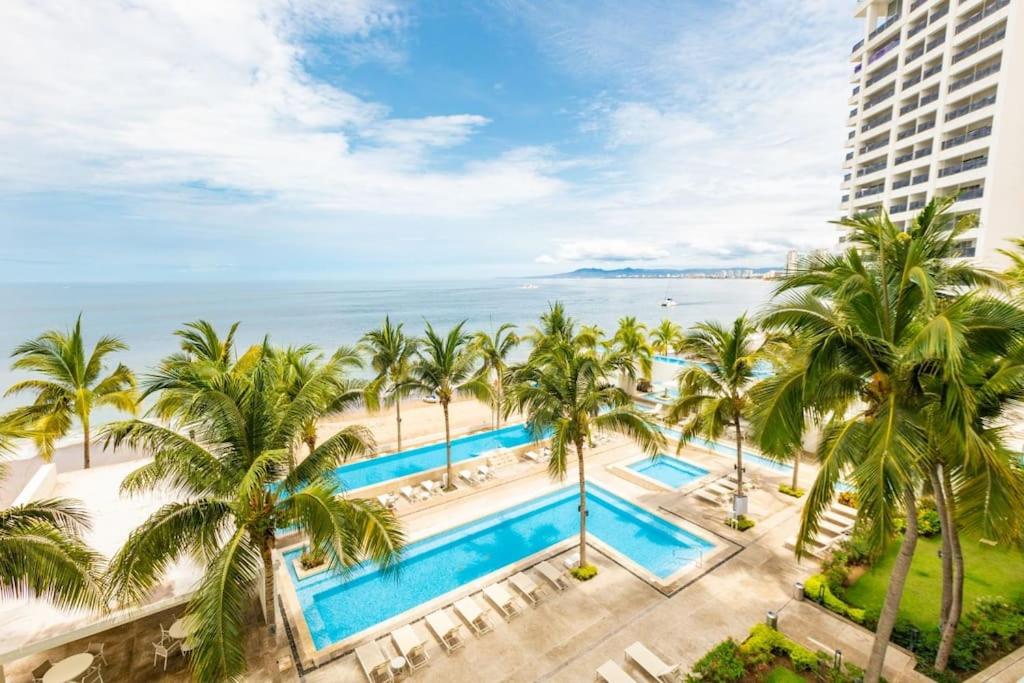 an aerial view of a resort with palm trees and the ocean at Serene Beachfront Escape Includes Delicious Breakfast in Puerto Vallarta