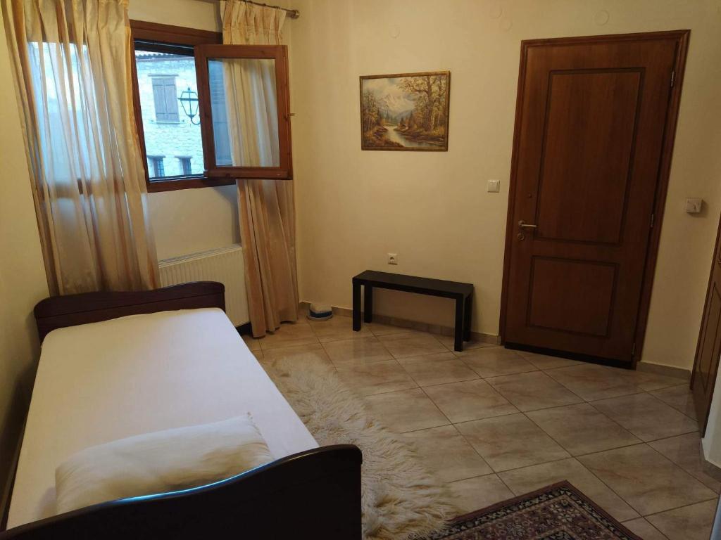 Kleines Zimmer mit einem Bett und einer Tür in der Unterkunft Arachova Cozy in Arachova