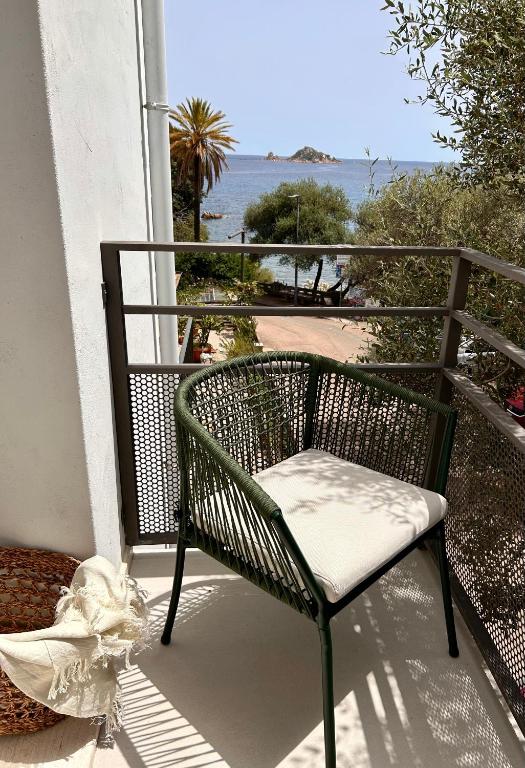 a chair on a balcony with a view of the ocean at Vireo Rooms in Santa Maria Navarrese