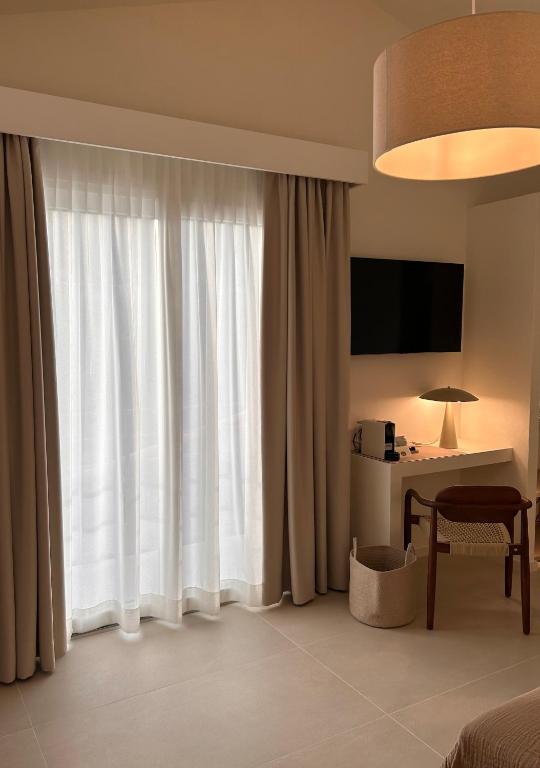 a hotel room with a bed and a desk and a window at Vireo Rooms in Santa Maria Navarrese