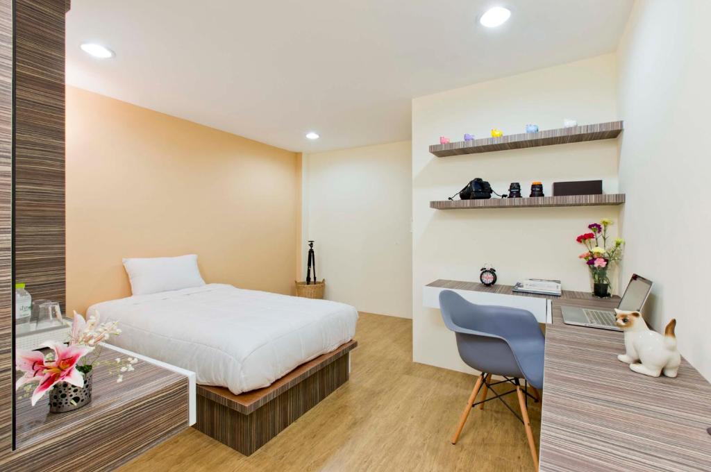 バンコクにあるタナブーミのベッドルーム1室(ベッド1台、デスク、コンピュータ付)
