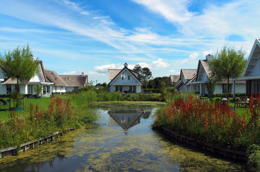 a river in a residential neighborhood with houses at Buitenplaats Witte Raaf aan Zee in Noordwijk