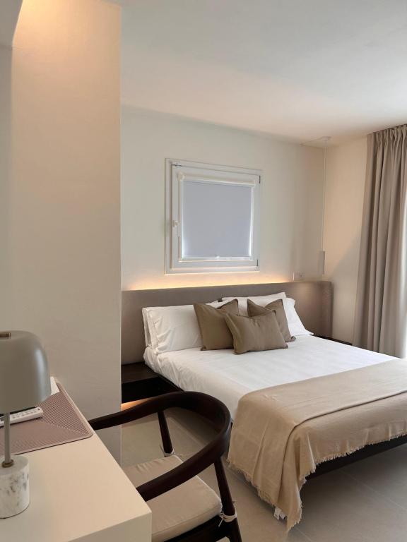 a bedroom with a bed and a desk and a window at Vireo Rooms in Santa Maria Navarrese