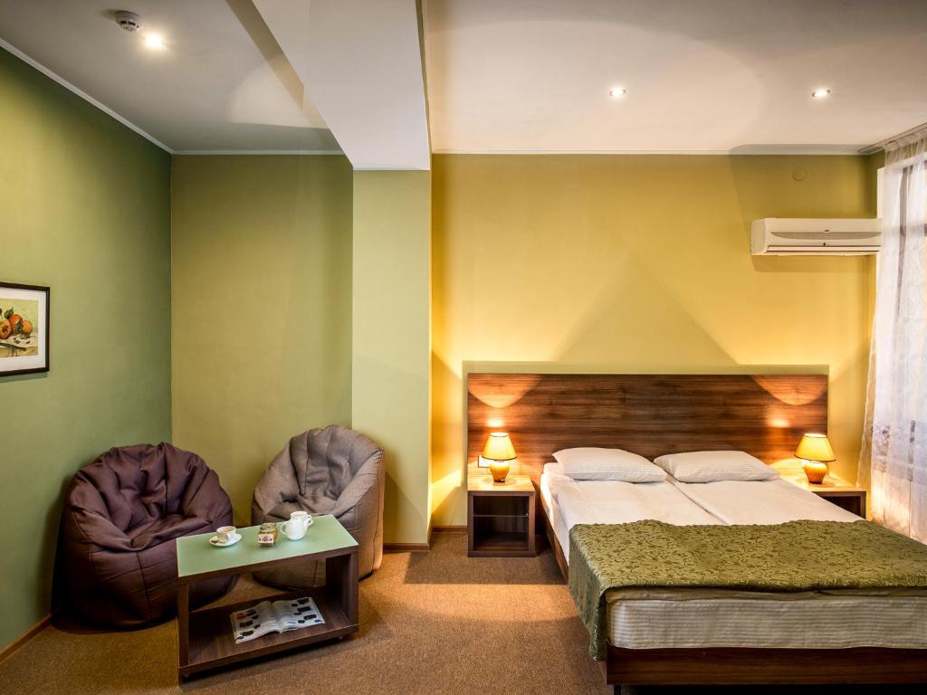 a bedroom with a bed and two chairs at Lviv Central Jam Hotel in Lviv