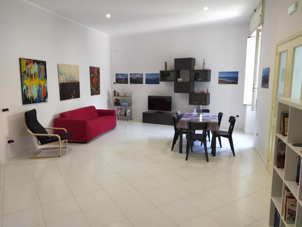un salon avec un canapé rouge et une table dans l'établissement Inside Naples-Dint'e'viche', à Naples