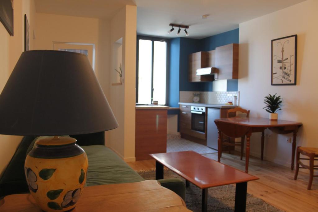 a living room with a couch and a table with a lamp at Comfortable Village Apartment in Barbieres with access to large garden with beautiful views in Barbières