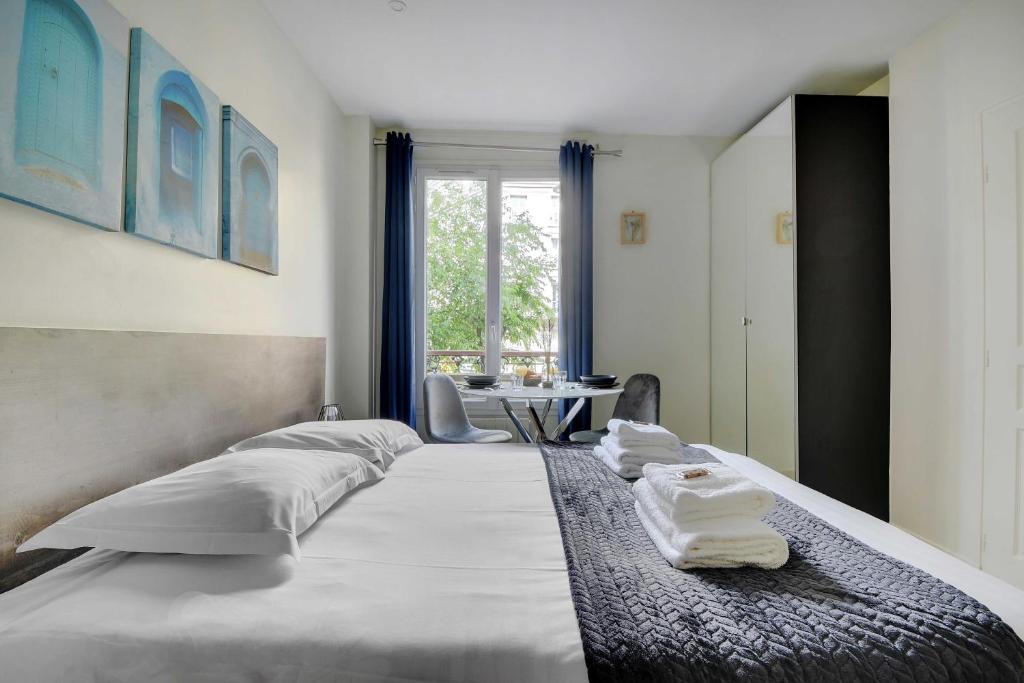 une chambre avec un grand lit avec des serviettes dessus dans l'établissement Comfort studio at Gare de l Est, à Paris