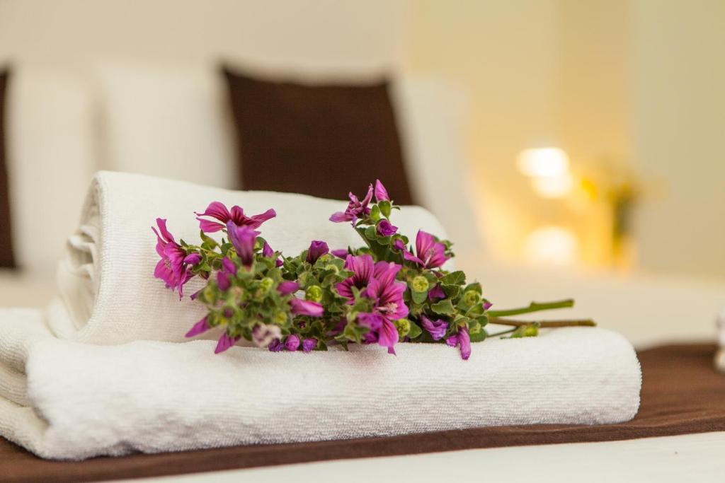 a bouquet of purple flowers sitting on a towel at Hostal Doris in Colònia de Sant Jordi