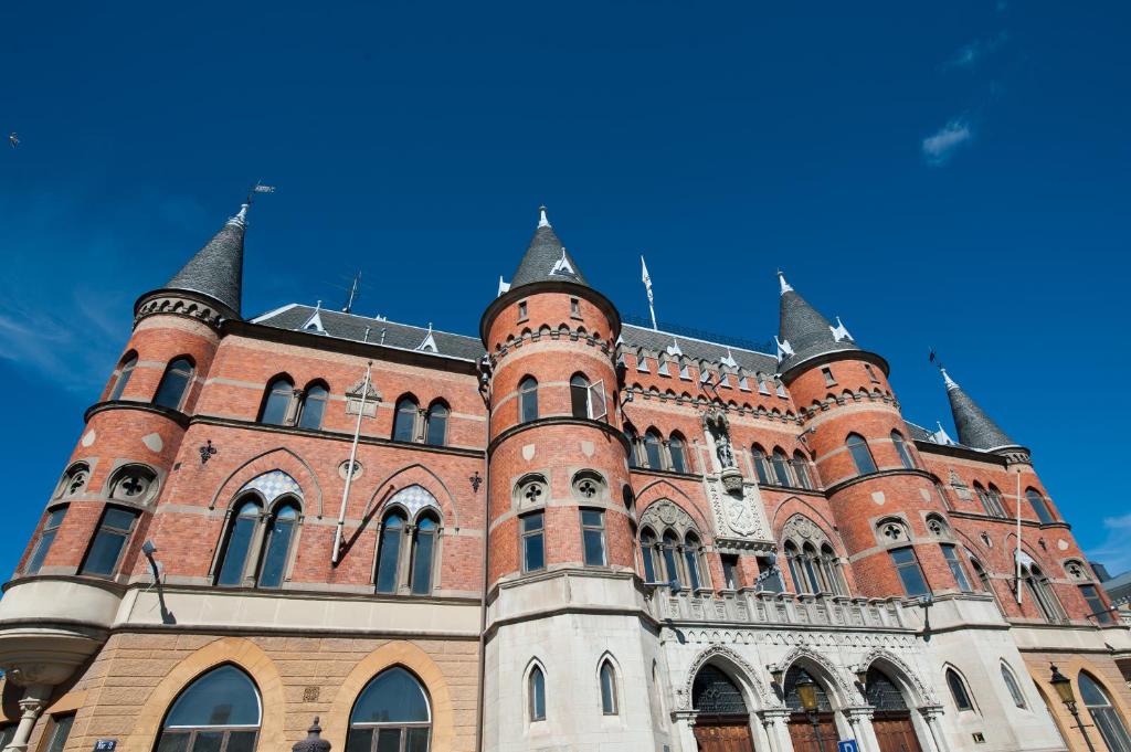ein großes Backsteingebäude mit Türmen am blauen Himmel in der Unterkunft Clarion Collection Hotel Borgen in Örebro