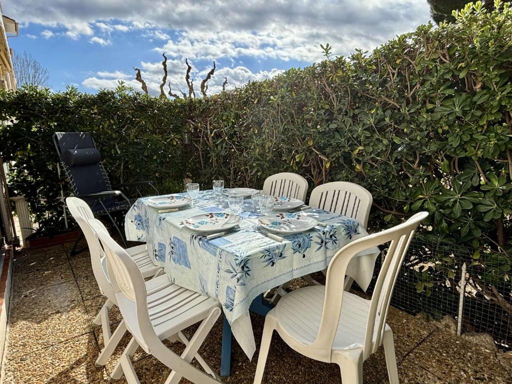 une table avec quatre chaises et un chiffon de table bleu et blanc dans l'établissement Appartement Studio cabine 4 couchages ARGELES SUR MER AR020-027, à Argelès-sur-Mer