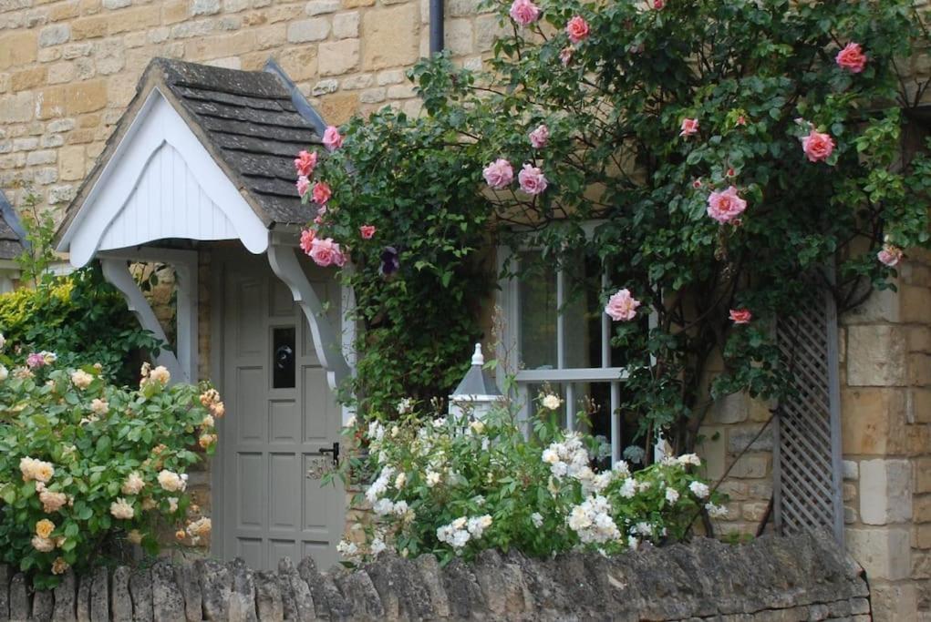a house with flowers on the side of it at Rose Cottage, Chipping Campden in Chipping Campden