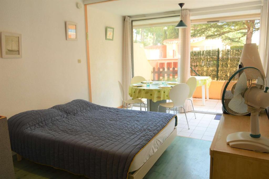 une chambre avec un lit et une table avec des chaises dans l'établissement Appartement Studio cabine 4 couchages ARGELES SUR MER AR070-408, à Argelès-sur-Mer