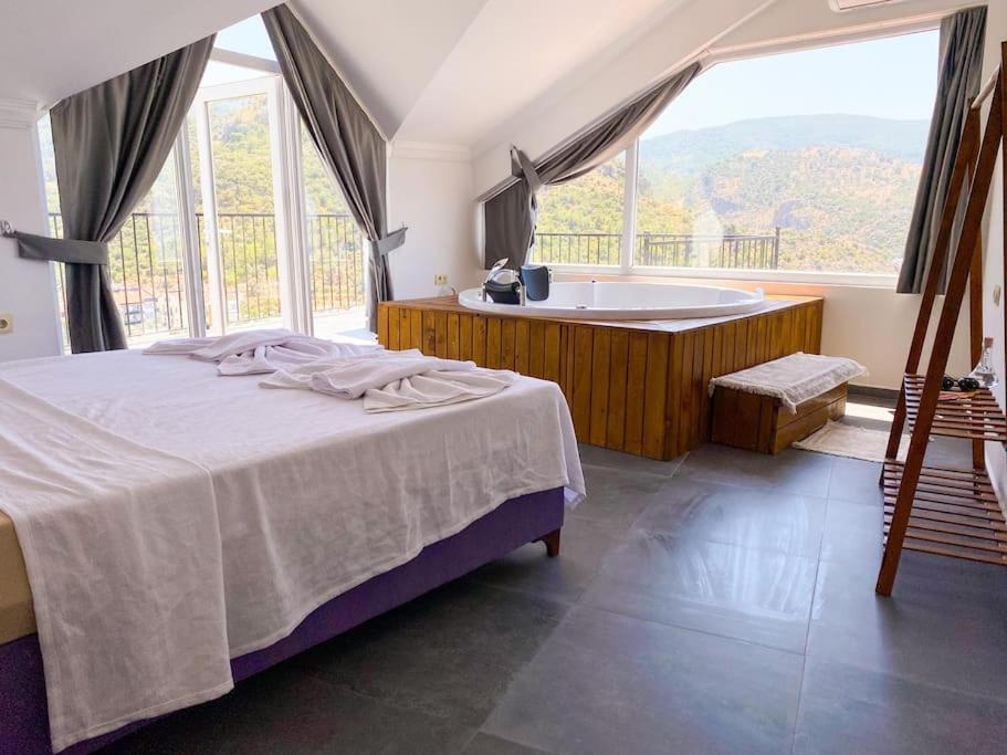 una camera con letto, vasca e finestra di Luna House - Manzara, jakuzi, 4 yatak odası a Fethiye