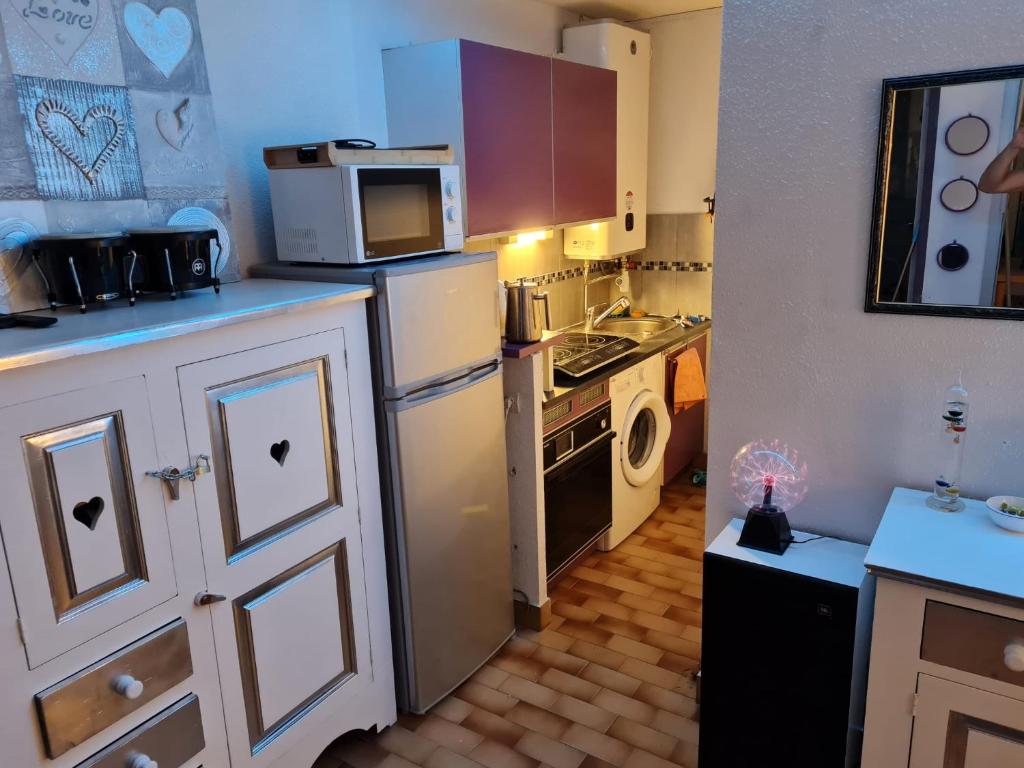 une petite cuisine avec une cuisinière et un micro-ondes dans l'établissement Studio 4 pers 100m plage et commerces, au Cap d'Agde