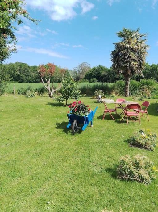 une cour avec des chaises et une table avec un pot de fleurs dans l'établissement Appartement Pont l'Abbé Entre océan et campagne, à Pont-lʼAbbé
