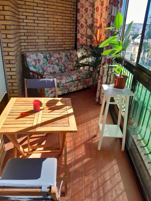 een kamer met een tafel en een bank op een balkon bij Casa Adriana, balcon y parking Habitacion en piso compartido in Almuñécar
