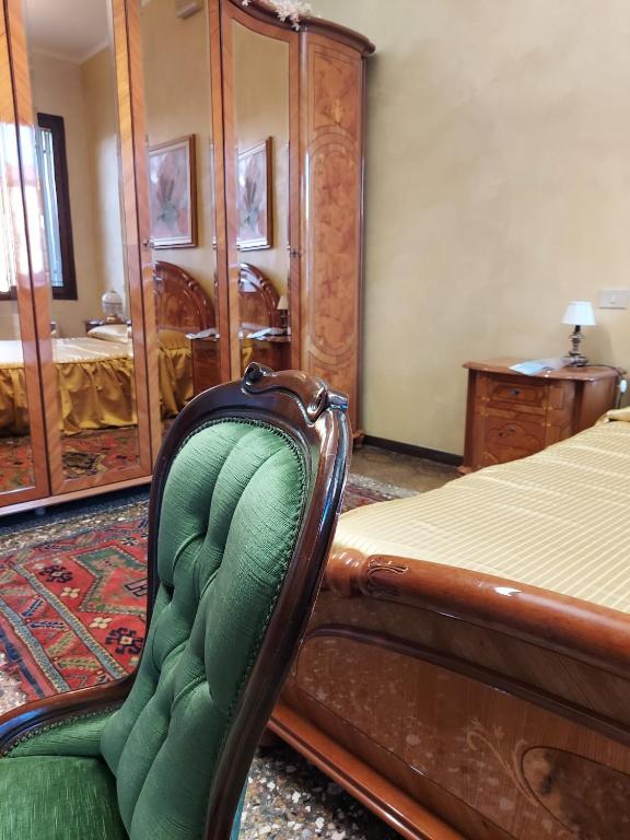 a bedroom with a bed and a chair in it at Ca' del Pavone mare e golf nel Delta del Po in Adria