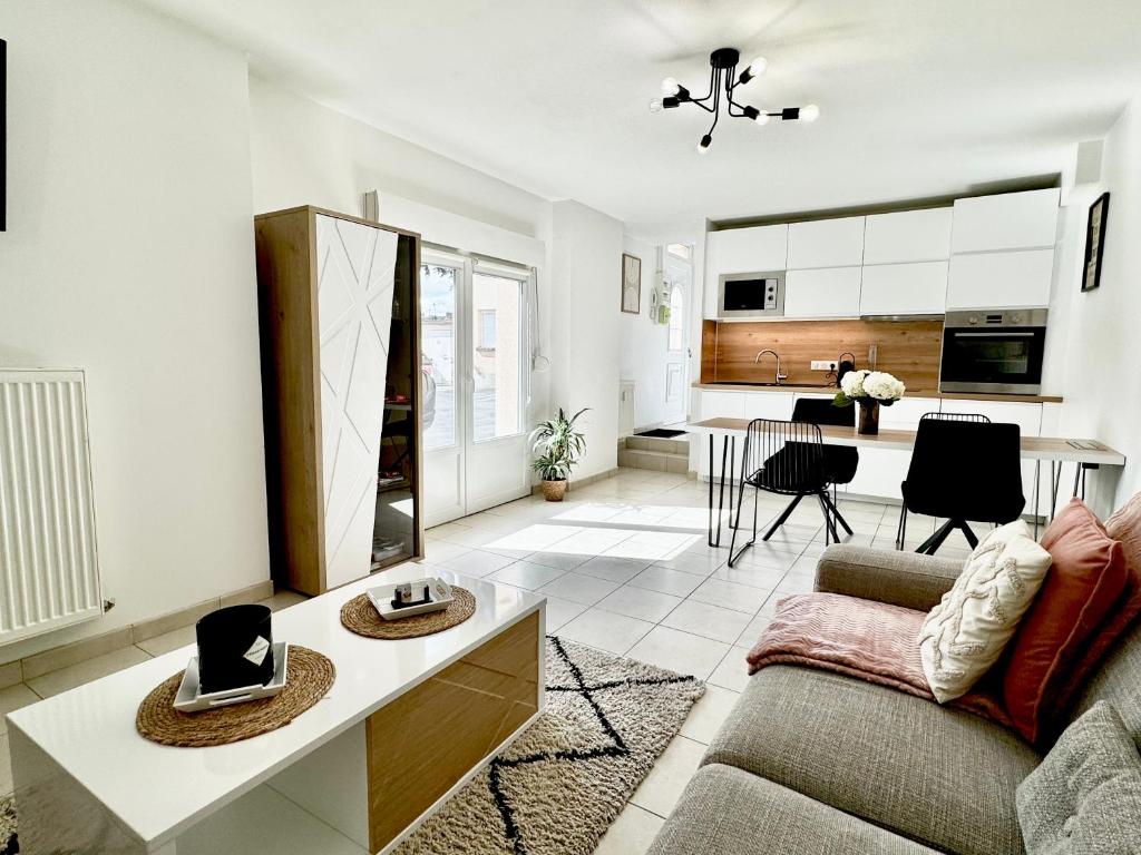 un salon avec un canapé et une cuisine dans l'établissement Le Cubry : Appart hyper-centre avec une place de parking, à Épernay