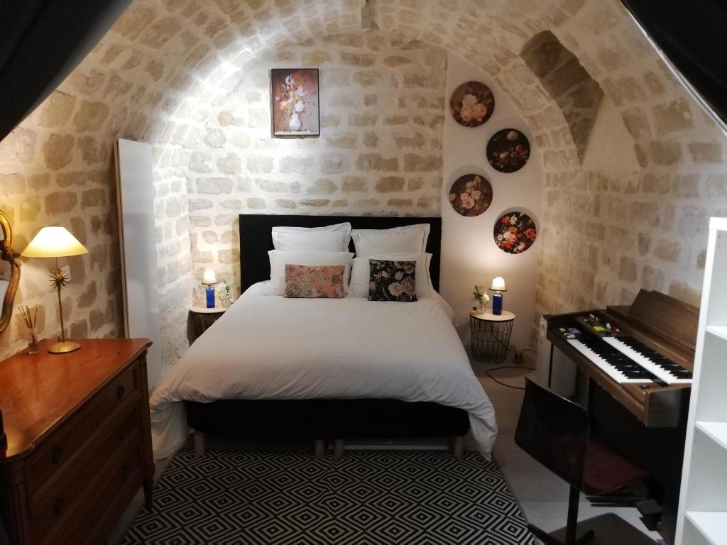 une chambre avec un lit et un piano dans l'établissement Les Frères Montgolfier - Le Marais - 80 m2, à Paris