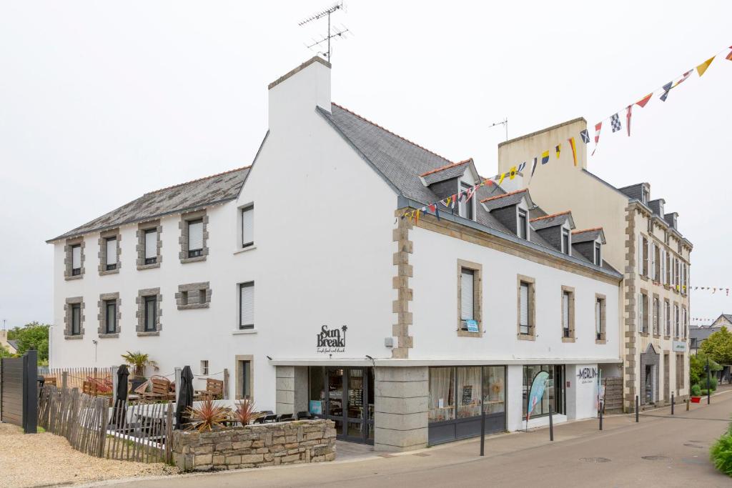 un bâtiment blanc au coin d'une rue dans l'établissement Résidence Saint Nicolas, à Beg-Meil