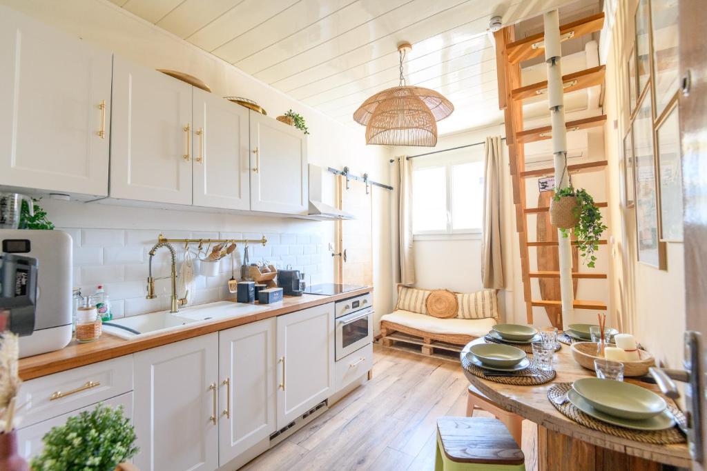 une cuisine avec des armoires blanches et une table en bois dans l'établissement LA PERLE, Studio 50 m de la PLAGE , parking, clim, Rivage Privilège, à La Seyne-sur-Mer