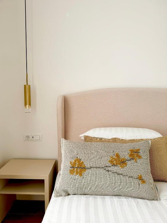 a bedroom with a bed with a pillow and a lamp at Feel Boutique Rooms in Oristano