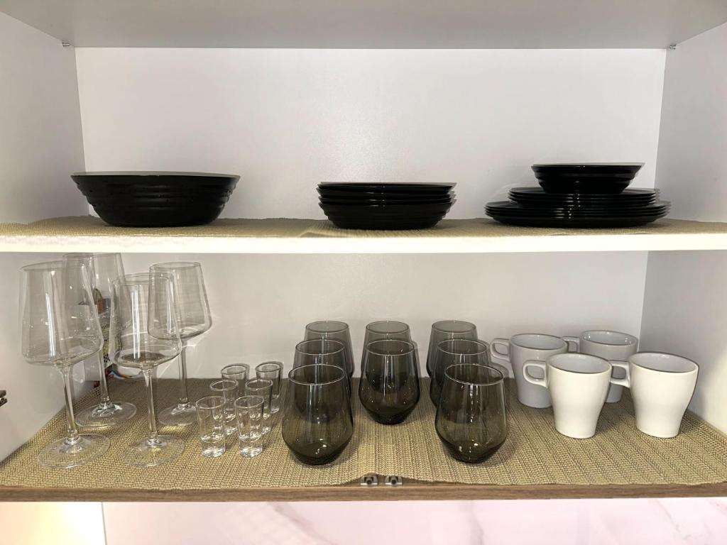 ノヴィサドにあるLU Apartmentのワイングラスと皿が入った棚
