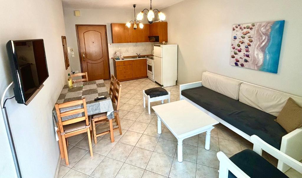 un soggiorno e una cucina con divano e tavolo di Mina Apartments 3 Nea Kallikrateia a Nea Kalikratia