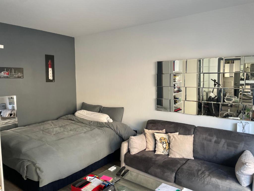 un salon avec un canapé et un lit dans l'établissement Trocadéro studio, à Paris