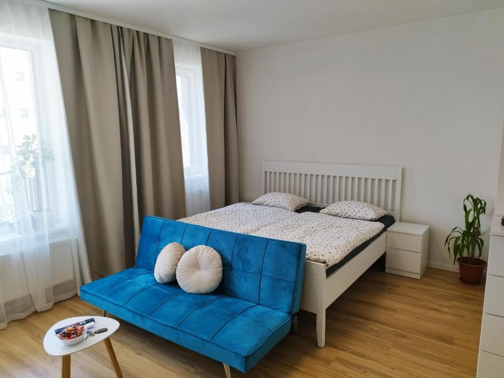a bedroom with a bed and a blue couch at Prechodná stanica in Brezno