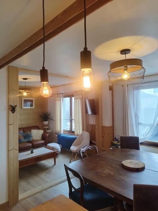 un salon avec une table à manger et un salon avec un canapé dans l'établissement Peisey Vallandry, L'appartement au pied des pistes, à Landry