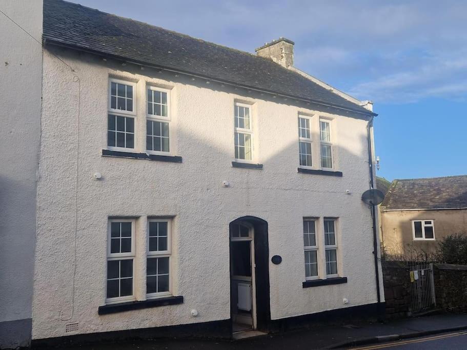 a white brick house with a blue door at The Old Bank at St Bees, Western Lakes in St Bees