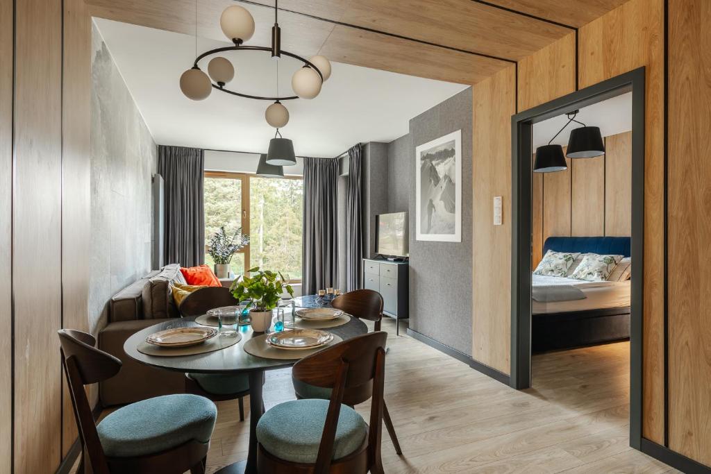 una sala da pranzo con tavolo e sedie e una camera da letto di Apartament Górski Przystanek a Szklarska Poręba