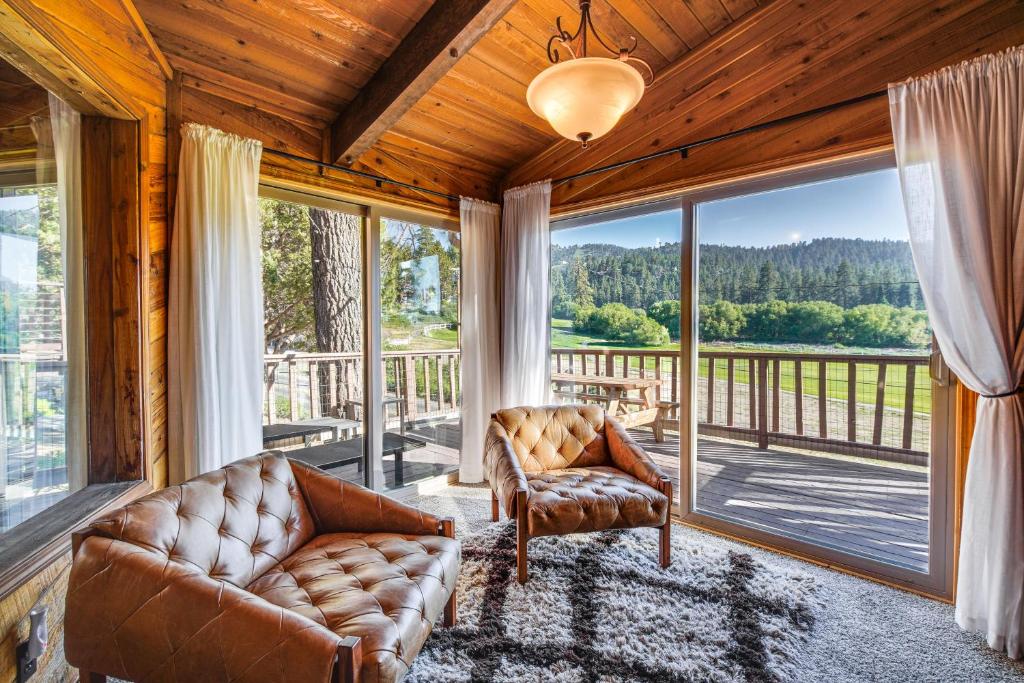 Una sala de estar con un sofá y sillas en un balcón. en Hot Tub and Game Room Spacious Big Bear Lake Cabin, en Big Bear Lake