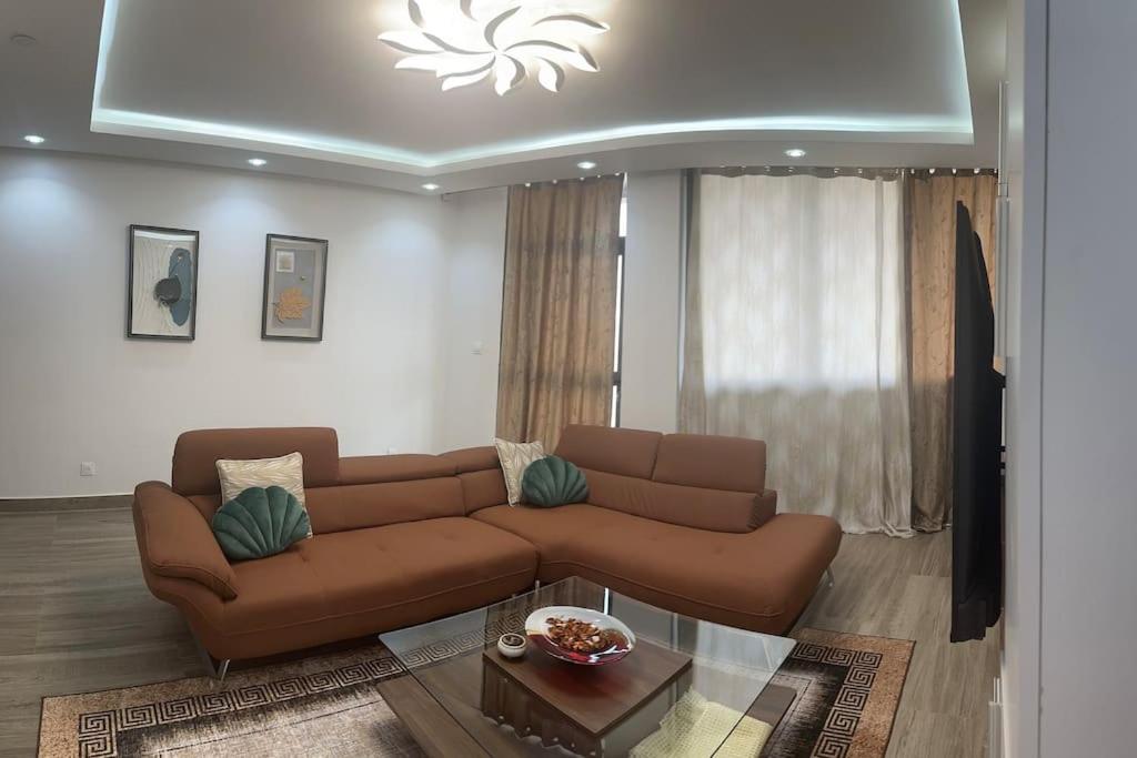 a living room with a brown couch and a table at BB immo dakar in Dakar