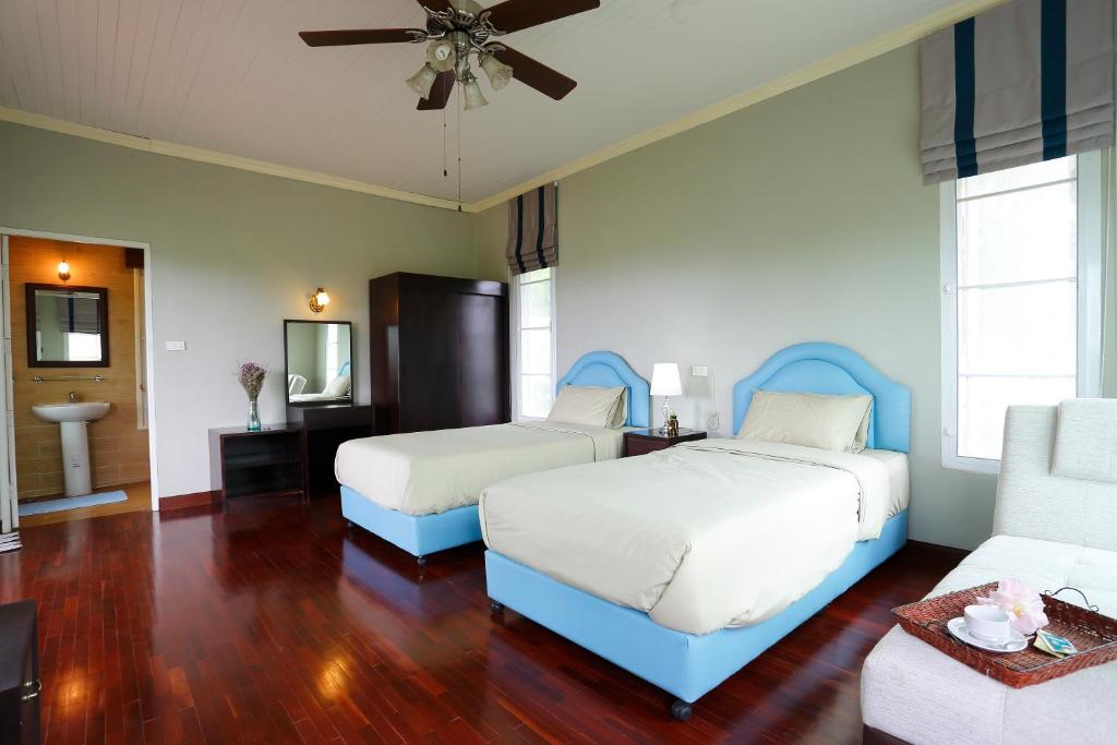 - une chambre avec deux lits et un canapé dans l'établissement Khaoyai Nature Retreat, à Baan Wang Mi
