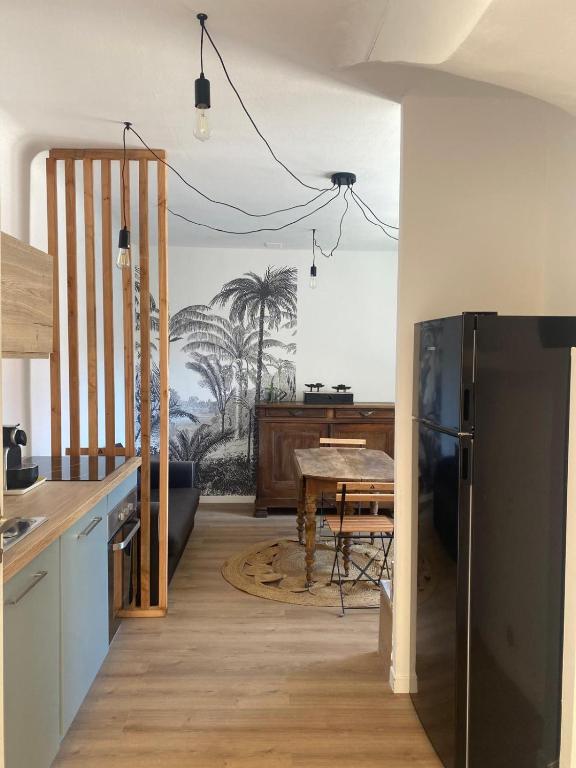 une cuisine avec une table et une salle à manger dans l'établissement Jolie maison de village, à Nissan-lez-Enserune