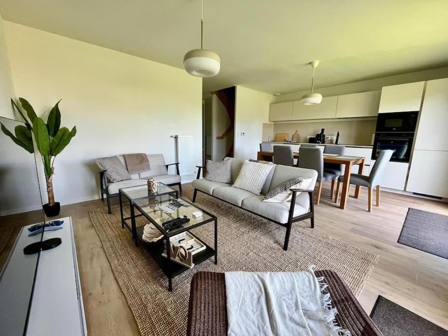a living room with a couch and a table at La Maison Bleue, Jardin & Mer 300m in Dunkerque